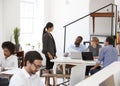 Woman talking with colleagues at a desk in open plan office Royalty Free Stock Photo