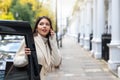 Woman talking on her mobile phone whilst steps off a black cab taxi in London, UK Royalty Free Stock Photo