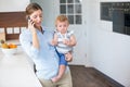 Woman talking on mobile phone while carrying daughter Royalty Free Stock Photo