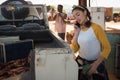 Woman talking on mobile phone while filling petrol in car Royalty Free Stock Photo