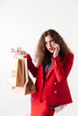 Woman talking on mobile phone and holding paper shopping bags Royalty Free Stock Photo