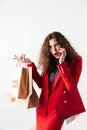 Woman talking on mobile phone and holding paper shopping bags Royalty Free Stock Photo