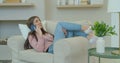 Woman talking on the mobile phone at home close up sit on sofa. Slow Motion.