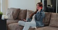 Woman talking mobile phone at home. Happy young woman using smartphone in cozy living room at home. People lifestyle Royalty Free Stock Photo