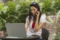 Woman talking on a mobile phone and using a laptop Royalty Free Stock Photo