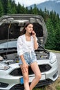 woman talking over a phone stand near broken car at road Royalty Free Stock Photo