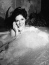 Woman talking on phone in bubble bath Royalty Free Stock Photo