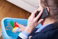 Woman talking on phone and cleaning up kids toys Royalty Free Stock Photo