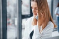 Woman talking by phone in front of group of young successful team that working and communicating together indoors in Royalty Free Stock Photo