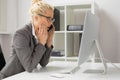 Woman talking on the phone and looking at computer in shock