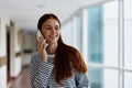 A woman talking on the phone in the office of a building and looking out the window at the big city. High quality photo Royalty Free Stock Photo