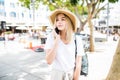 Young woman talking by phone outdoors in city street. Portrait of young smiling fashion girl standing with smartphone Royalty Free Stock Photo