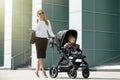 Woman talking on the phone and pushing baby stroller Royalty Free Stock Photo