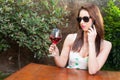 Woman talking at phone raising glass of wine Royalty Free Stock Photo