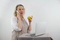 woman talking on phone is upset and displeased in hands she has apple dietetics proper nutrition menu recipes in front