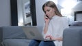 Woman Talking on Phone while Working on Laptop