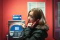 A girl is talking on a public telephone at night on the street. Royalty Free Stock Photo