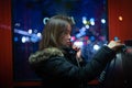 A girl is talking on a public telephone at night on the street. Royalty Free Stock Photo