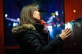 A girl is talking on a public telephone at night on the street. Royalty Free Stock Photo