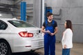 Woman talking to car repairer about repair Royalty Free Stock Photo