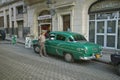 Woman talking to driver of old green car in Old Havana, Cuba Royalty Free Stock Photo