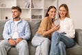 Woman Talking To Female Friend Using Smartphone Ignoring Husband Indoors Royalty Free Stock Photo