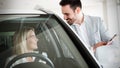 Woman is talking to handsome car dealership worker while choosing a car Royalty Free Stock Photo