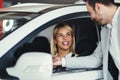 Woman is talking to handsome car dealership worker while choosing a car Royalty Free Stock Photo