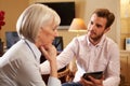 Woman Talking To Male Counsellor Using Digital Tab