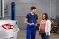 Woman talking to a mechanic about car repair Royalty Free Stock Photo