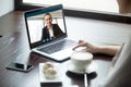 Woman talking to man in headphones via video call.