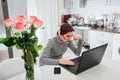 Woman talking working on laptop on modern kitchen. Angry irritated freelancer staring at screen