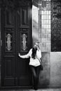 A woman talks on her cell phone. She is standing in front of a traditional house on a street in Porto?