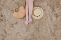 Woman tanned legs, straw hat and bag on sand beach. Travel concept. Relaxing at a beach, with your feet on the sand Royalty Free Stock Photo