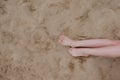 Woman tanned legs, straw hat and bag on sand beach. Travel concept. Relaxing at a beach, with your feet on the sand Royalty Free Stock Photo