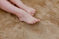 Woman tanned legs, straw hat and bag on sand beach. Travel concept. Relaxing at a beach, with your feet on the sand Royalty Free Stock Photo