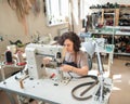 A woman tanner sews a leather belt on a sewing machine. Royalty Free Stock Photo