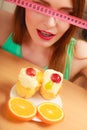 Woman with tape measure and cake. Diet dilemma. Royalty Free Stock Photo