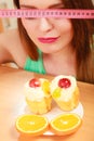 Woman with tape measure and cake. Diet dilemma. Royalty Free Stock Photo