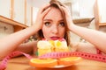 Woman with tape measure and cake. Diet dilemma. Royalty Free Stock Photo