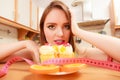 Woman with tape measure and cake. Diet dilemma. Royalty Free Stock Photo