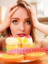 Woman with tape measure and cake. Diet dilemma. Royalty Free Stock Photo