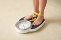 Woman with tape standing on floor scales. Overweight problem