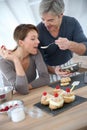 Woman tasting cake preparation made by her husband