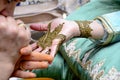 A woman tattooed the bride`s hand with henna. Moroccan wedding. The traditions of the Maghreb. Royalty Free Stock Photo