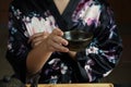 Woman tea master in kimono performs tea ceremony. Matcha green tea powder with a bamboo whisk and scoop Royalty Free Stock Photo