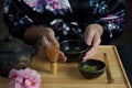 Woman tea master in kimono performs tea ceremony. Matcha green tea powder with a bamboo whisk and scoop Royalty Free Stock Photo