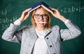 Woman teacher with book as roof on head. Memorizing method. Train memory every day. Effective method to remember