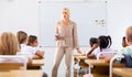 Woman teacher standing at whiteboard during lesson with tweens