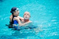 Woman teacher help to training support elder man swimming at the pool for healthy activity at home care